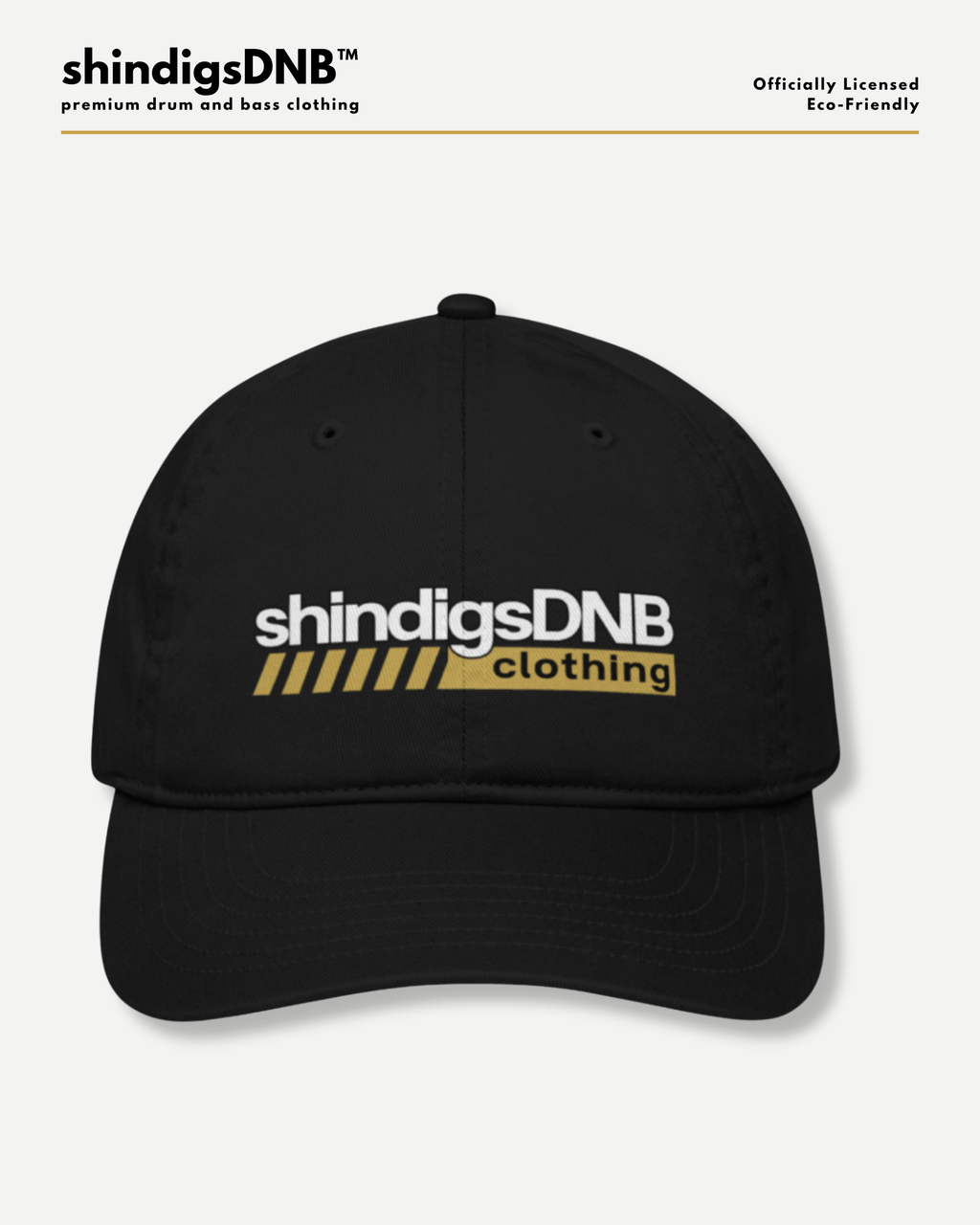 A black baseball cap with 'shindigsDNB clothing' printed on the front in white and yellow, shown against a light gray background with brand text at the top.