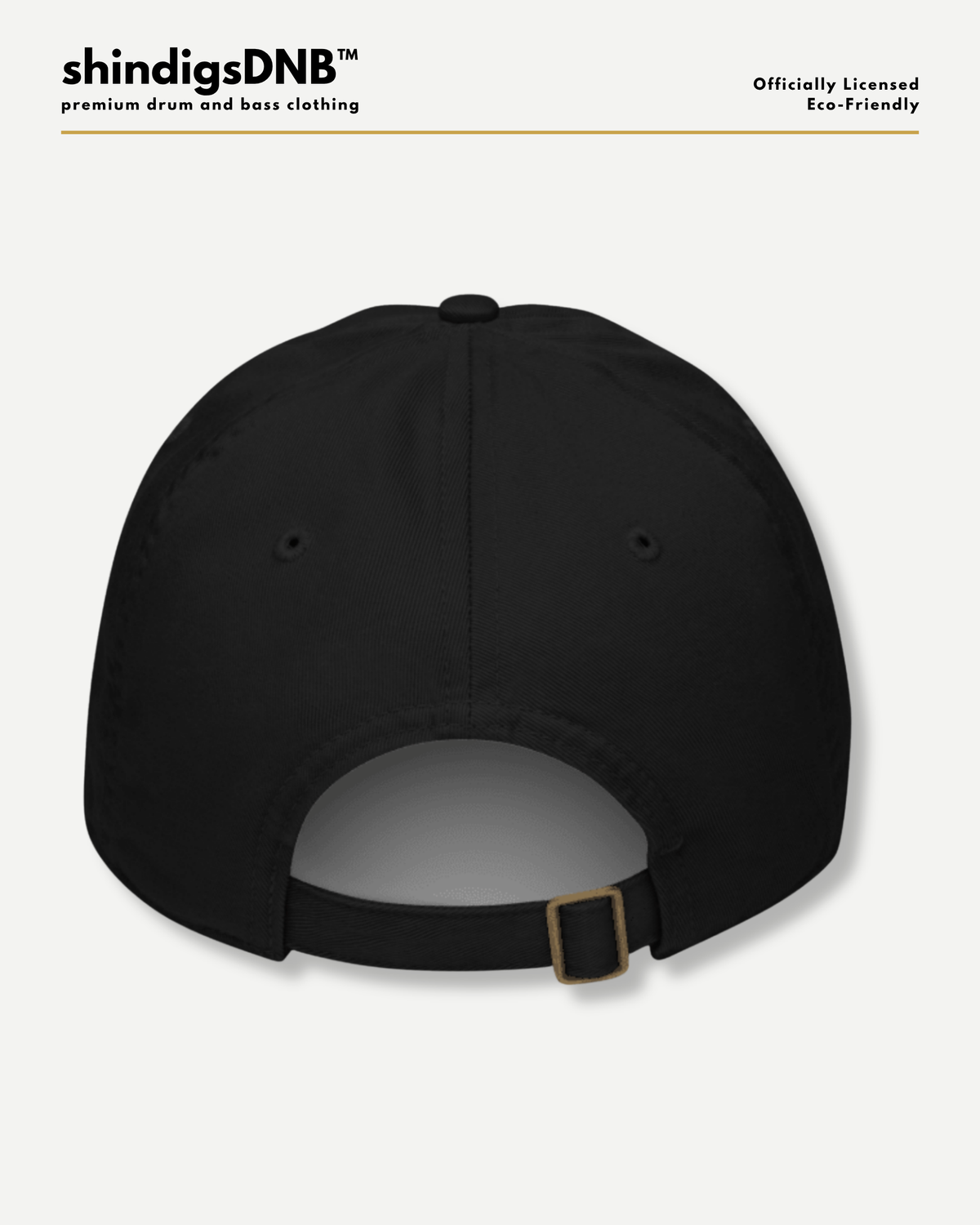 Black baseball cap shown from the back with an adjustable strap and a small gold-tone buckle, photographed on a light gray background. Brand text 'shindigsDNB' appears at the top left, with 'Officially Licensed Eco-friendly' at the top right.