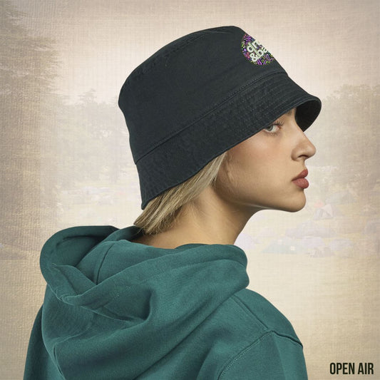 Woman wearing a dark blue beanie with a colorful design on a textured beige background
