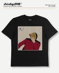 A black short-sleeve graphic t-shirt by shindigsDNB, featuring a square print of an illustrated figure in a red jacket and gold hat on a beige background. The t-shirt is displayed flat against a light gray background with the brand logo 'shindigsDNB' at the top.
