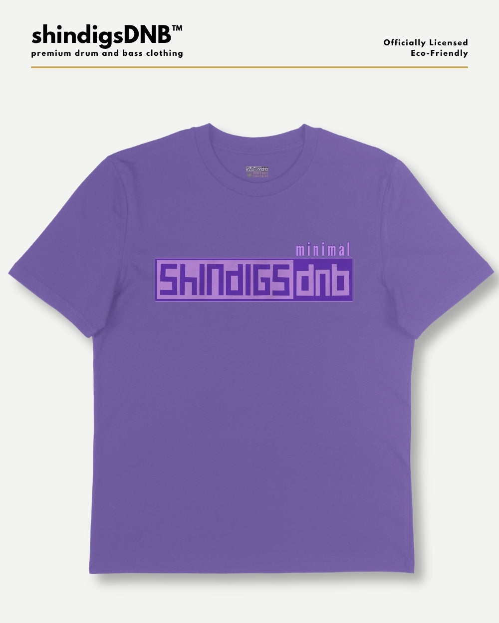 A purple short-sleeve t-shirt with a graphic print on the chest reading 'minimal SHINDIGS dnb' in a blocky purple font, displayed on a light gray background with branding text at the top.