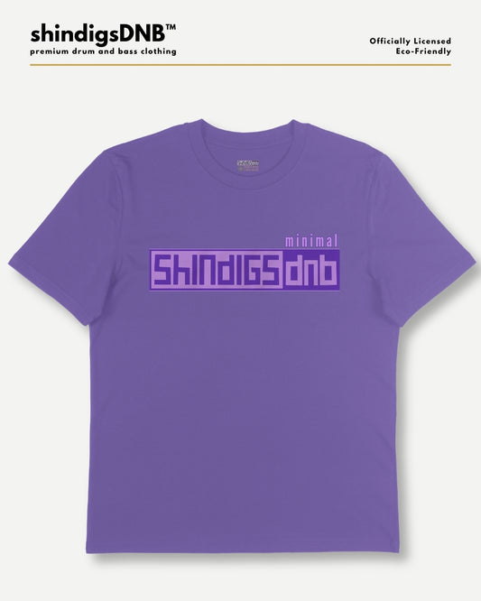 A purple short-sleeve t-shirt with a graphic print on the chest reading 'minimal SHINDIGS dnb' in a blocky purple font, displayed on a light gray background with branding text at the top.