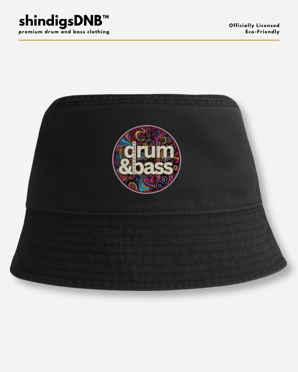 A black bucket hat with a colorful circular graphic on the front that reads 'drum & bass' in white text over a psychedelic pattern. The hat is displayed on a light gray background with 'shindigsDNB' branding at the top.